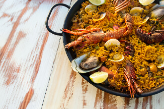 Seafood paella on the wooden table close-up