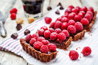 chocolate tart with chocolate filling and fresh raspberries. toning. selective focus