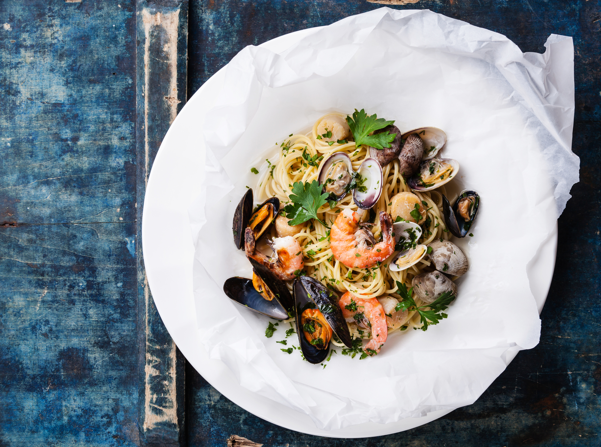 Seafood pasta - Spaghetti with clams, prawns, sea scallops on white plate