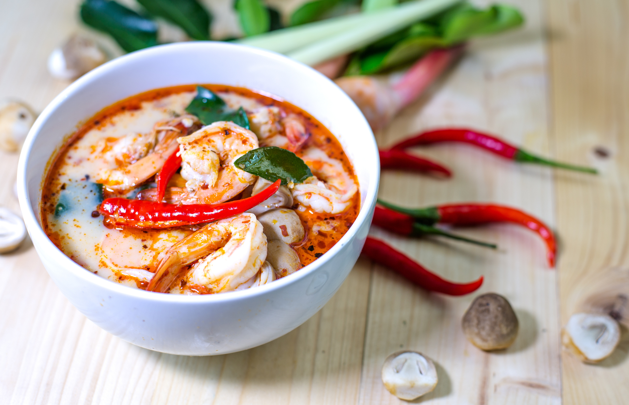 Tom yum kung, and condiment, on wooden table, Select focus